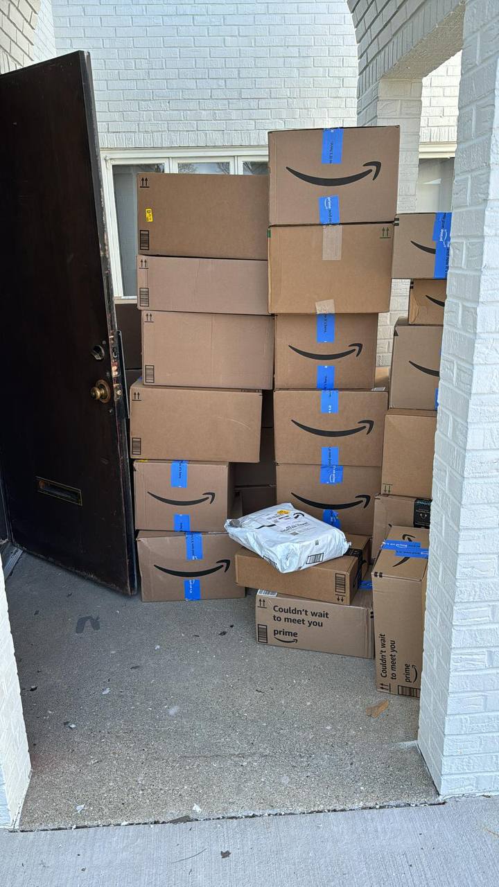 Stacked Amazon cartons delivered at a doorway