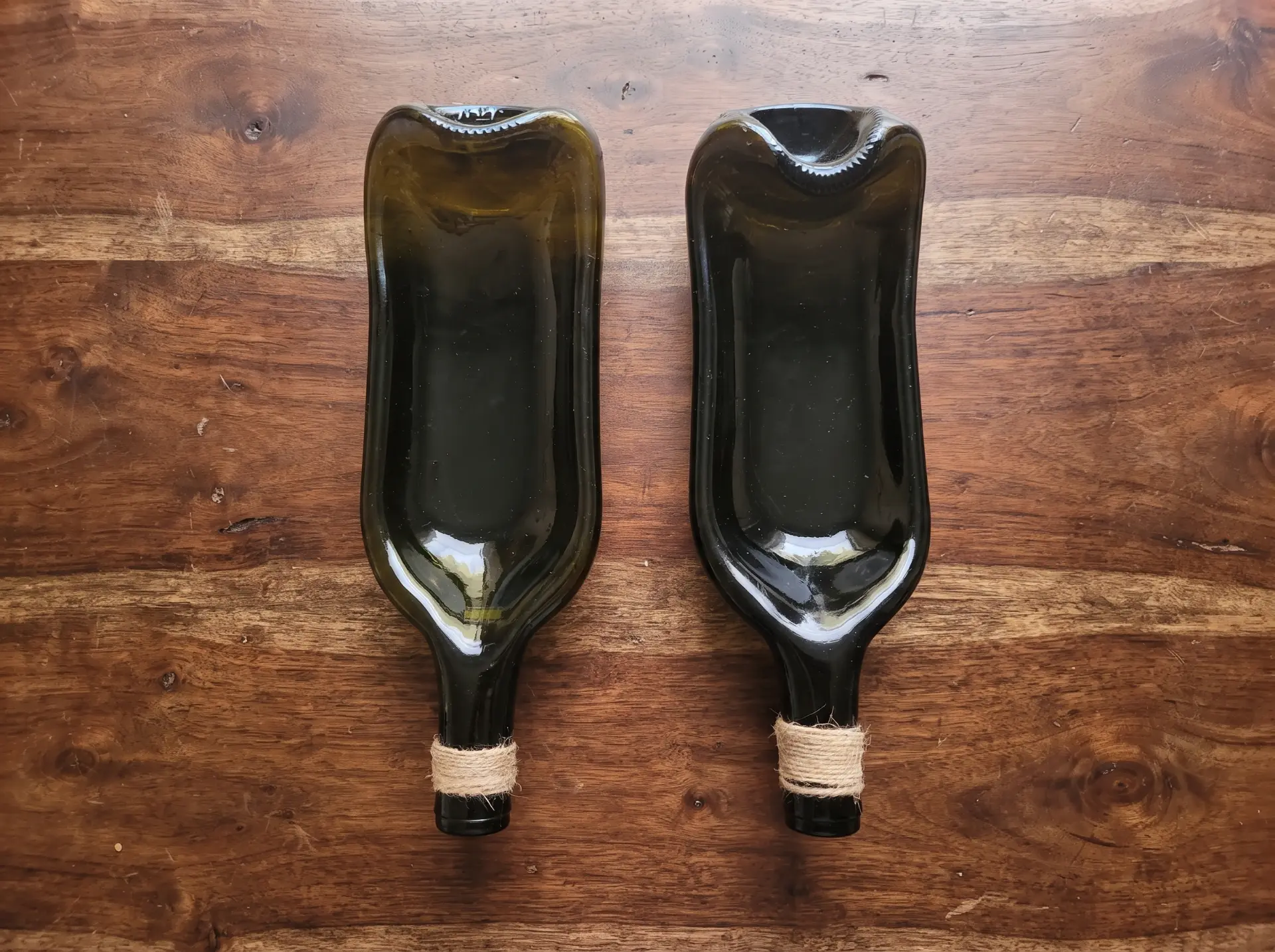 Two unbranded dark glass bottles photographed on a wooden table at the original product stage